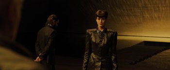 Movie still from “Blade Runner 2049” (2017), directed by Denis Villeneuve – A man and a woman are standing in a dark room; Medium shot, Over the shoulder angle