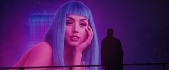 Movie still from “Blade Runner 2049” (2017), directed by Denis Villeneuve – A man standing in front of a large picture of a woman with long blue hair; Extreme Close Up shot, Over the shoulder angle