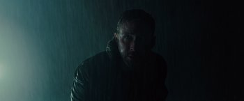Movie still from “Blade Runner 2049” (2017), directed by Denis Villeneuve – A man in a black jacket in the rain; Close Up shot, Low angle
