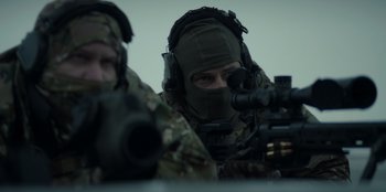 Movie still from “Blood Red Sky” (2021), directed by Peter Thorwarth – Two men in military uniforms are looking through a rifle scope; Close Up shot, Low angle