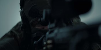 Movie still from “Blood Red Sky” (2021), directed by Peter Thorwarth – A man with a rifle looking through a scope; Extreme Close Up shot, Over the shoulder angle