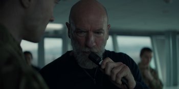 Movie still from “Blood Red Sky” (2021), directed by Peter Thorwarth – An older man with a beard is holding an electric toothbrush; Close Up shot, Low angle