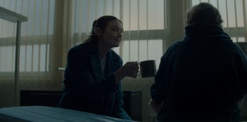 Movie still from “Blood Red Sky” (2021), directed by Peter Thorwarth – A woman holding a coffee cup in her hand; Medium shot, Over the shoulder angle