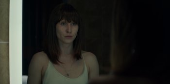 Movie still from “Blood Red Sky” (2021), directed by Peter Thorwarth – A woman in a white tank top is looking at the camera; Close Up shot, Over the shoulder angle