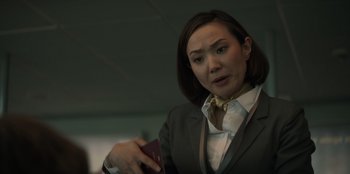 Movie still from “Blood Red Sky” (2021), directed by Peter Thorwarth – A woman in a suit and tie holding a passport; Close Up shot, Low angle