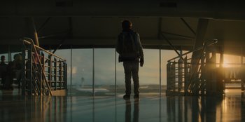 Movie still from “Blood Red Sky” (2021), directed by Peter Thorwarth – A man standing in front of an airport window; Wide shot, Low angle