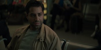 Movie still from “Blood Red Sky” (2021), directed by Peter Thorwarth – A person sitting on a bench; Close Up shot, Over the shoulder angle