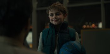 Movie still from “Blood Red Sky” (2021), directed by Peter Thorwarth – A young boy holding a ball in his hand; Close Up shot, Over the shoulder angle