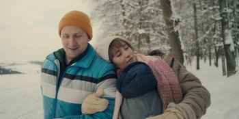 Movie still from “Blood Red Sky” (2021), directed by Peter Thorwarth – A man and a woman hugging in the snow; Medium shot, Over the shoulder angle