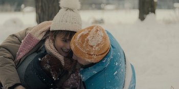 Movie still from “Blood Red Sky” (2021), directed by Peter Thorwarth – Two children are playing in the snow together; Close Up shot, Over the shoulder angle