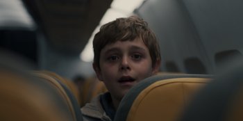 Movie still from “Blood Red Sky” (2021), directed by Peter Thorwarth – A young boy sitting on a seat on a train; Close Up shot, Low angle
