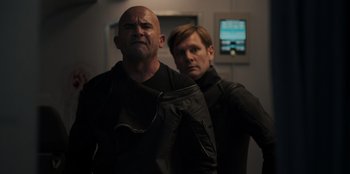 Movie still from “Blood Red Sky” (2021), directed by Peter Thorwarth – A man and a woman standing next to each other; Medium shot, Over the shoulder angle