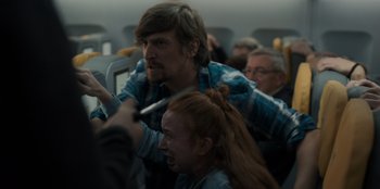 Movie still from “Blood Red Sky” (2021), directed by Peter Thorwarth – A man and a woman on an airplane; Medium shot, Over the shoulder angle