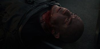 Movie still from “Blood Red Sky” (2021), directed by Peter Thorwarth – A man laying on the ground covered in blood; Close Up shot, High angle