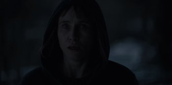 Movie still from “Blood Red Sky” (2021), directed by Peter Thorwarth – A woman in a hooded sweatshirt stares into the camera; Close Up shot, Over the shoulder angle