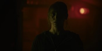 Movie still from “Blood Red Sky” (2021), directed by Peter Thorwarth – A person with headphones in a dark room; Close Up shot, Over the shoulder angle