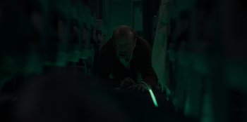 Movie still from “Blood Red Sky” (2021), directed by Peter Thorwarth – A man in a dark room looking at a computer screen; Medium shot, High angle