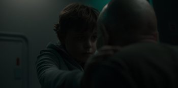 Movie still from “Blood Red Sky” (2021), directed by Peter Thorwarth – A young boy looking into a mirror in a dark room; Close Up shot, Over the shoulder angle