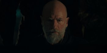 Movie still from “Blood Red Sky” (2021), directed by Peter Thorwarth – An old man with a beard is looking at the camera; Close Up shot, Low angle
