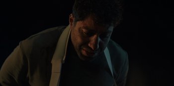 Movie still from “Blood Red Sky” (2021), directed by Peter Thorwarth – A person wearing a suit and tie; Close Up shot, High angle