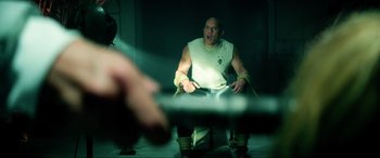 Movie still from “Bloodshot” (2020), directed by Dave Wilson – A man sitting on a chair in a dark room; Medium shot, Over the shoulder angle