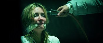 Movie still from “Bloodshot” (2020), directed by Dave Wilson – A woman being held down by a person holding a pair of pliers over her face; Close Up shot, Over the shoulder angle