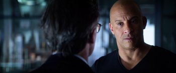 Movie still from “Bloodshot” (2020), directed by Dave Wilson – A bald man with glasses is talking to a man in a suit; Close Up shot, Over the shoulder angle