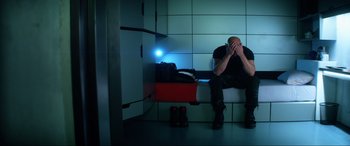 Movie still from “Bloodshot” (2020), directed by Dave Wilson – A man sitting on a bench with his hands over his face; Medium shot, Low angle