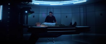 Movie still from “Bloodshot” (2020), directed by Dave Wilson – A man laying on top of a bed next to another man; Wide shot, High angle