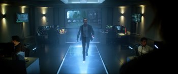 Movie still from “Bloodshot” (2020), directed by Dave Wilson – A man walking down a hallway in front of a computer screen; Wide shot, Low angle