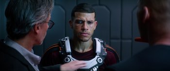 Movie still from “Bloodshot” (2020), directed by Dave Wilson – A young man wearing a body armor looking into the camera; Close Up shot, Over the shoulder angle