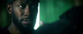 Movie still from “Bloodshot” (2020), directed by Dave Wilson – A man's face with a green background; Close Up shot, Over the shoulder angle