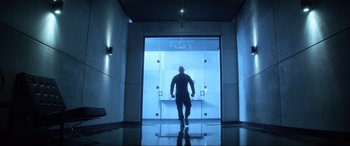 Movie still from “Bloodshot” (2020), directed by Dave Wilson – A man walking through a glass door in a building; Wide shot, Low angle