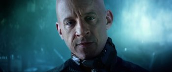 Movie still from “Bloodshot” (2020), directed by Dave Wilson – A bald man wearing a black jacket and a neck brace; Close Up shot, Low angle