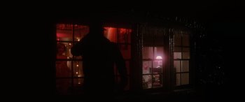 Movie still from “Blow Out” (1981), directed by Brian De Palma – A man standing in front of a window at night; Wide shot, Low angle