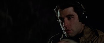 Movie still from “Blow Out” (1981), directed by Brian De Palma – A person wearing a jacket looking at the camera; Close Up shot, Over the shoulder angle