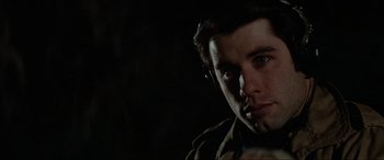 Movie still from “Blow Out” (1981), directed by Brian De Palma – A person with a dark background; Close Up shot, Over the shoulder angle