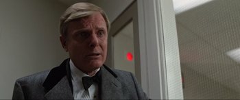 Movie still from “Blow Out” (1981), directed by Brian De Palma – A man in a suit and bow tie looking at the camera; Close Up shot, Low angle