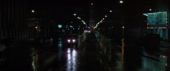 Movie still from “Blow Out” (1981), directed by Brian De Palma – A car driving down a street at night; Extreme Wide shot, High angle
