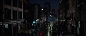 Movie still from “Blow Out” (1981), directed by Brian De Palma – Two people cross a street in the dark; Extreme Wide shot, High angle