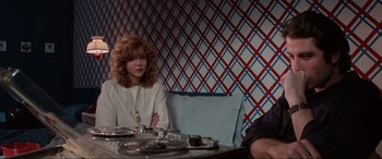 Movie still from “Blow Out” (1981), directed by Brian De Palma – A woman sitting at a table in front of a man; Medium shot, Over the shoulder angle