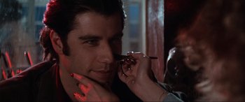 Movie still from “Blow Out” (1981), directed by Brian De Palma – A man is looking at a woman's face with a pair of scissors; Close Up shot, Over the shoulder angle