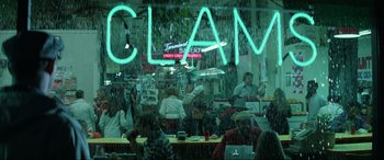 Movie still from “Blow Out” (1981), directed by Brian De Palma – People are sitting at tables in front of a restaurant; Extreme Wide shot, High angle