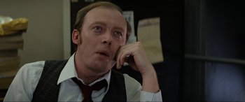 Movie still from “Blow Out” (1981), directed by Brian De Palma – A man in a vest and tie holding his hand up to his face; Close Up shot, Over the shoulder angle