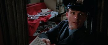 Movie still from “Blow Out” (1981), directed by Brian De Palma – A man sitting in front of a computer keyboard in a room; Close Up shot, Low angle