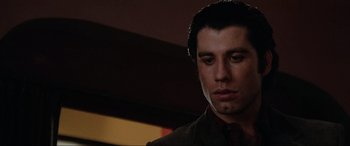 Movie still from “Blow Out” (1981), directed by Brian De Palma – A person wearing a suit and tie; Close Up shot, Low angle