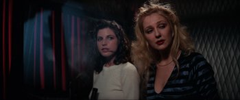 Movie still from “Blow Out” (1981), directed by Brian De Palma – Two women standing next to each other in front of a curtain; Close Up shot, Low angle