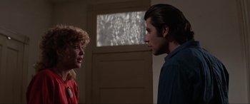 Movie still from “Blow Out” (1981), directed by Brian De Palma – A man and a woman standing next to each other in a room; Medium shot, Over the shoulder angle