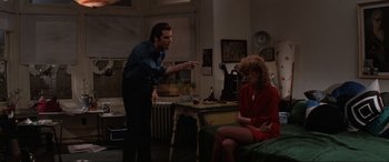 Movie still from “Blow Out” (1981), directed by Brian De Palma – A man and a woman sitting on a couch in a living room; Medium shot, Over the shoulder angle