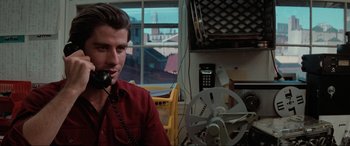 Movie still from “Blow Out” (1981), directed by Brian De Palma – A man sitting in front of a computer; Close Up shot, Low angle